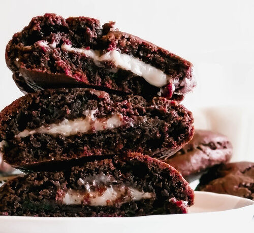 Stacked cookies on a white plate. Glass of milk in the background