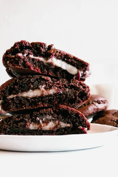 Stacked cookies on a white plate. Glass of milk in the background