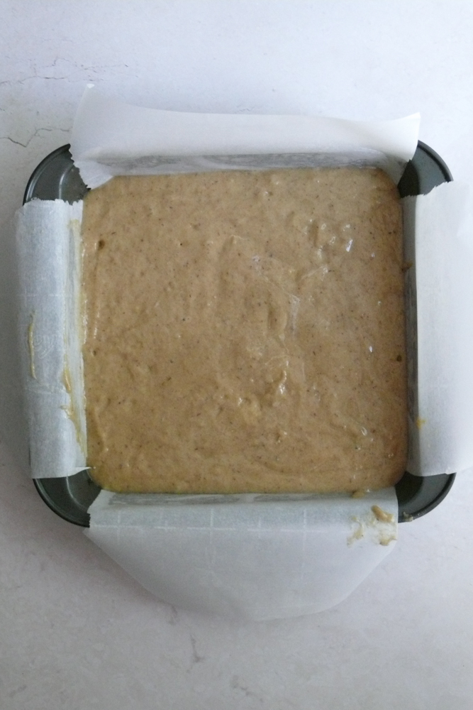 Uncooked date cake batter in an 8x8 pan