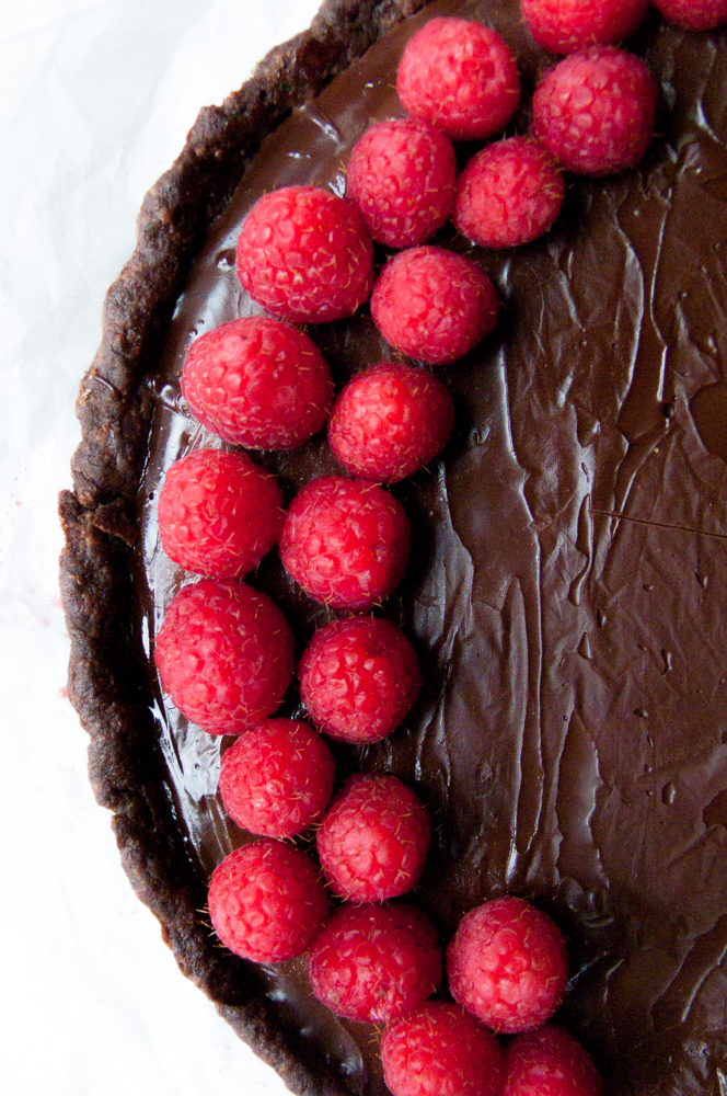 Macro shot of the tart highlighting the bright raspberries on top