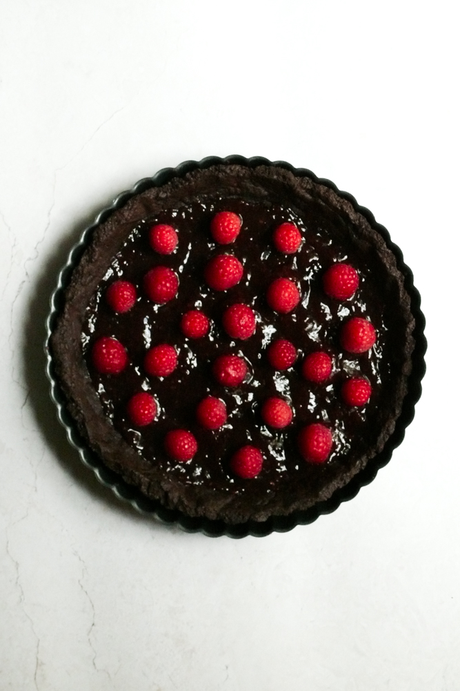 Raspberries and jam on an unfilled tart shell