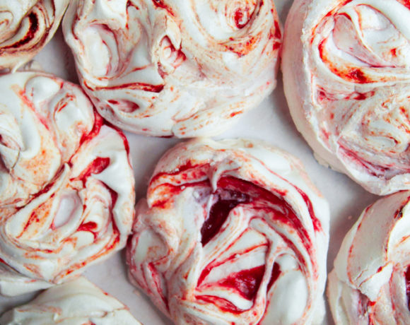 12 meringues lined up next to each other in an overhead shot