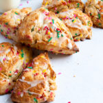 Funfetti scones stacked in a c shape with sprinkles behind them