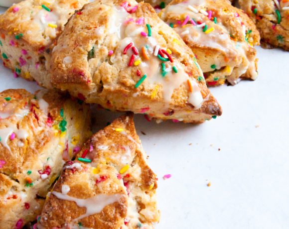 Funfetti scones stacked in a c shape with sprinkles behind them