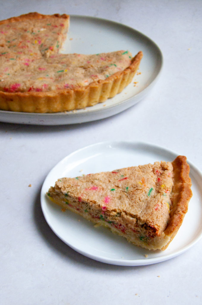 One slice laid out to focus on the crumb of this funfetti tart