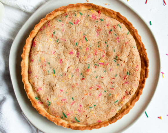 Full tart on a white plate surrounded by funfetti sprinkles