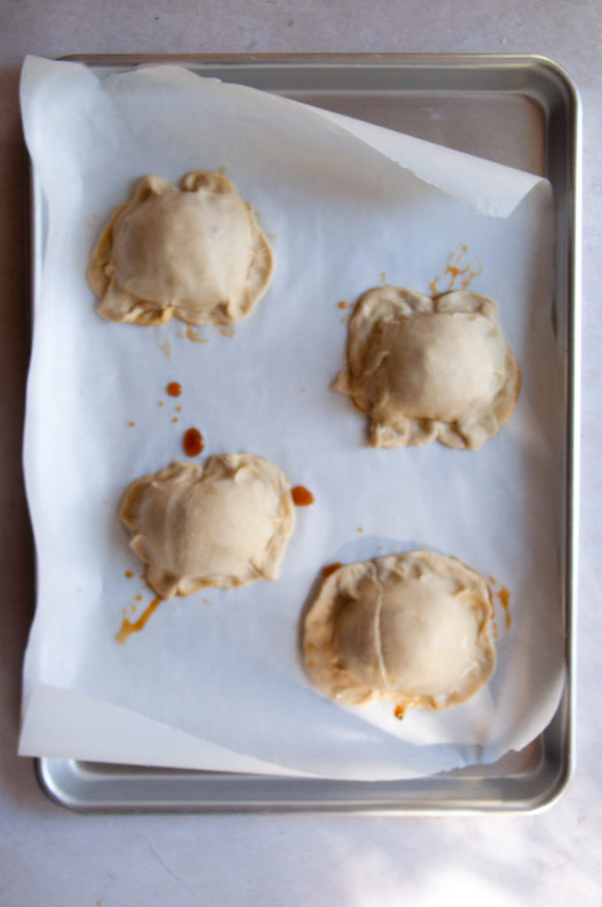 Fully assembled puff pastry tarts on a baking sheet