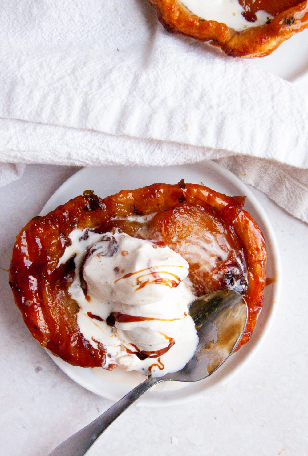 overhead apple tartlet topped with ice cream and caramel